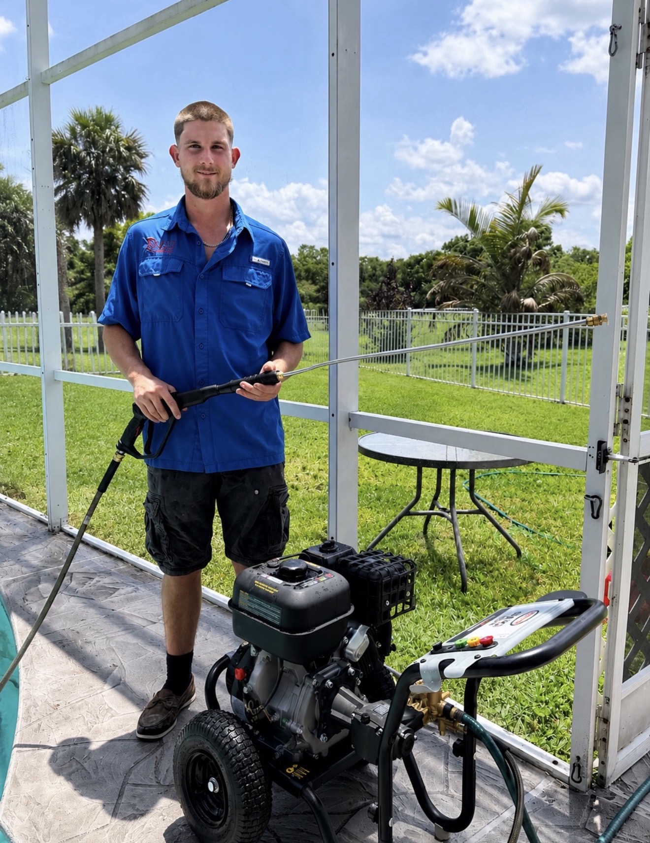 Jediah, owner of Exalt Pressure Washing, holding a professional pressure washer