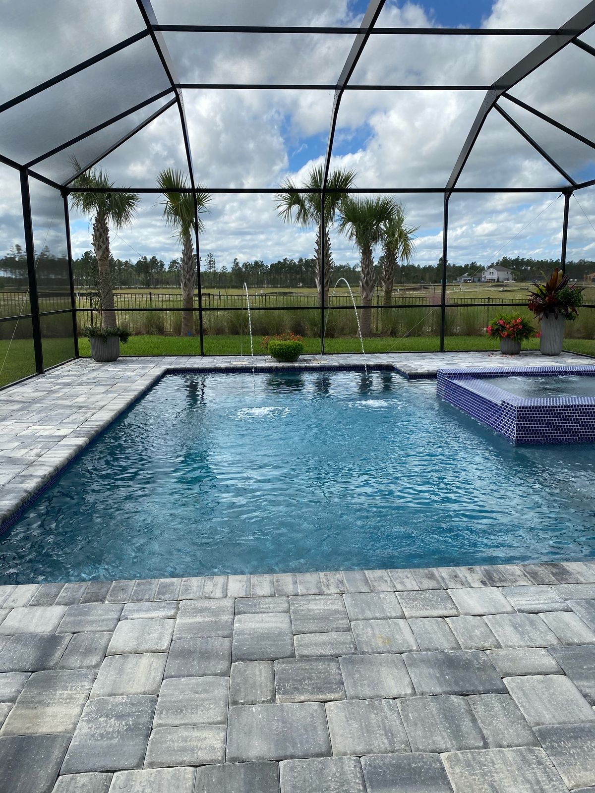 Pool enclosure screen repair with paver deck and fountains