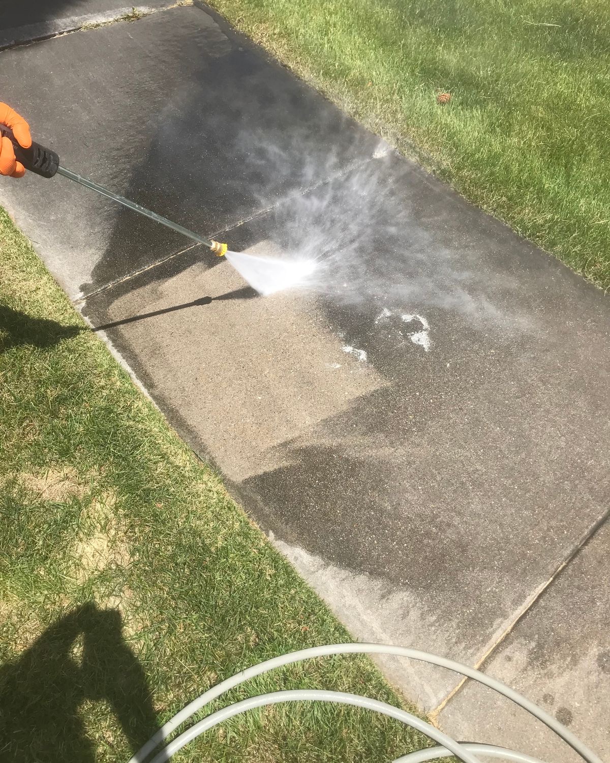 Concrete sidewalk being pressure washed